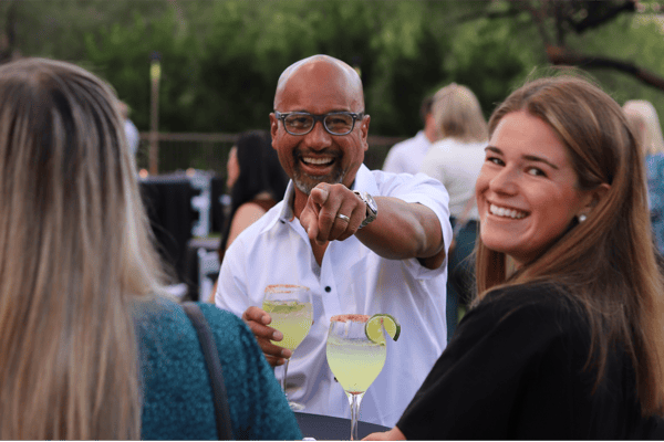 Man in crowd at Summit pointing at camera smiling